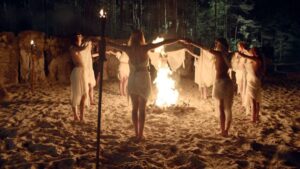 Photographie de femmes en cercle autour d'un feu.