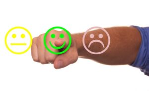 Illustration d'un doigt appuyant sur un smiley vert qui est encadré d'un rouge et d'un orange.