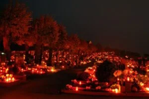 Photographie d'une multitude de bougies dans la nuit.