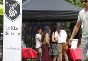 Photographie du stand du Klan du Loup, avec des visiteurs.